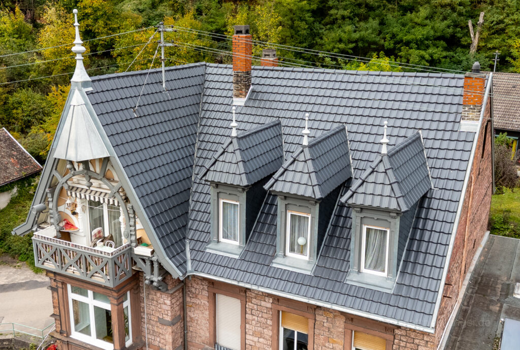 Drohnenaufnahme eines Villa Dachs mit vielen Gauben und spitzen Türmen